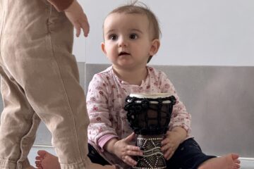 Bébé en crèche découvrant un tambour pendant un atelier d’éveil musical