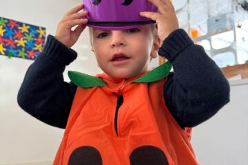 Enfant déguisé en citrouille lors de la fête d’Halloween à la crèche Les Libellules à Vannes, participant aux activités festives et sensorielles.