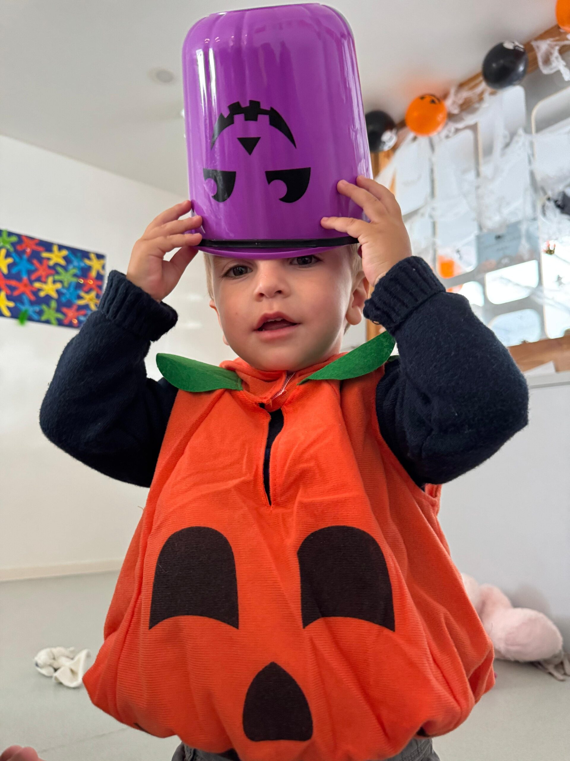 Enfant déguisé en citrouille lors de la fête d’Halloween à la crèche Les Libellules à Vannes, participant aux activités festives et sensorielles.